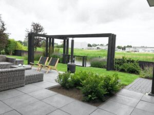 Moderne tuin met zwarte pergola en strak terras