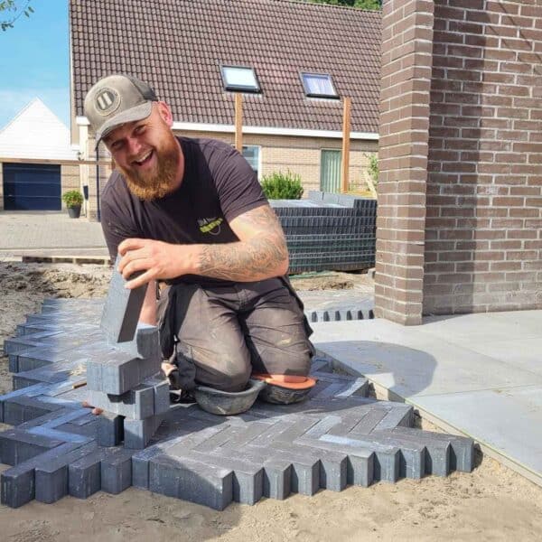 Professionele stratenmaker plaatst terrastegels bij woning