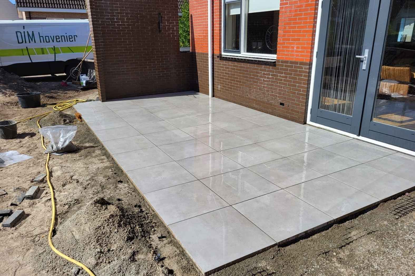 Aanleg van terras met grote keramische tegels